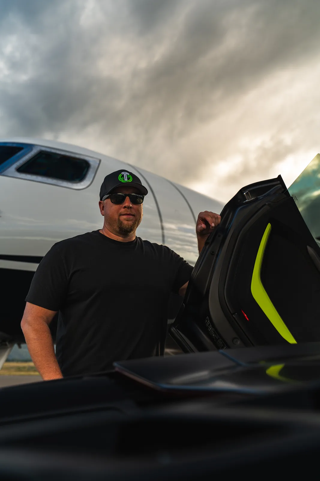 Matt standing at the open door of the Revuelto at golden hour, private jet behind