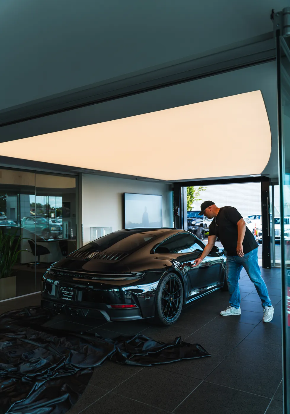 Matt uncovering the black Porsche 911 in the garage